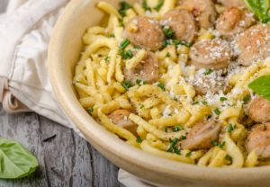 Spaetzle with slices of fried sausage